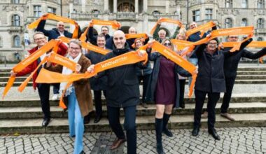 Personen stehen auf der Freitreppe vor dem Neuen Rathaus und halten Banner mit dem Schriftzug "Knowember" in den Händen.