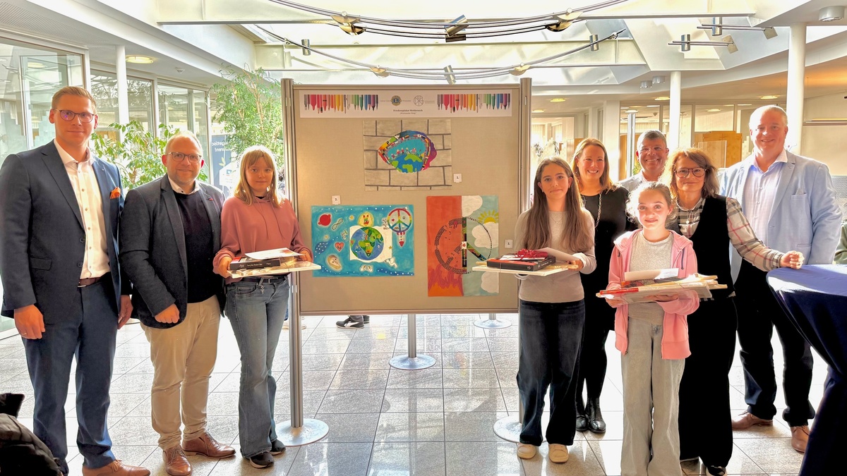 Ausstellung in der Bank: Hauke Klüssendorf (VR Bank), Bürgermeister Roger Nießen, Emily Pierednik (Platz 2), Mia Dobrijevic (Platz 1), Beate Roderburg Lions Club, Christof Klein VR Bank, Emma Rosenbaum (Platz 3), Svenja Harren-Poqué (Lions Club) und Frank Lüder (VR Bank) vor den drei Siegerbildern.