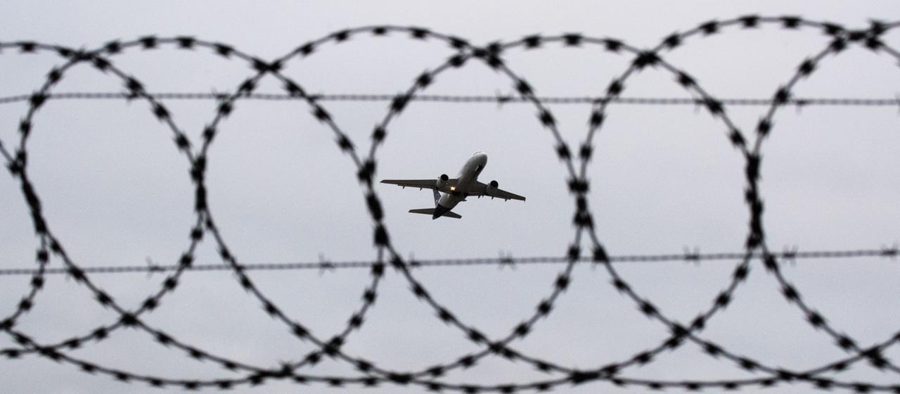 Ein Passagierflugzeug startet hinter einer Stacheldrahtabsperrung. | dpa Ein Passagierflugzeug startet hinter einer Stacheldrahtabsperrung.