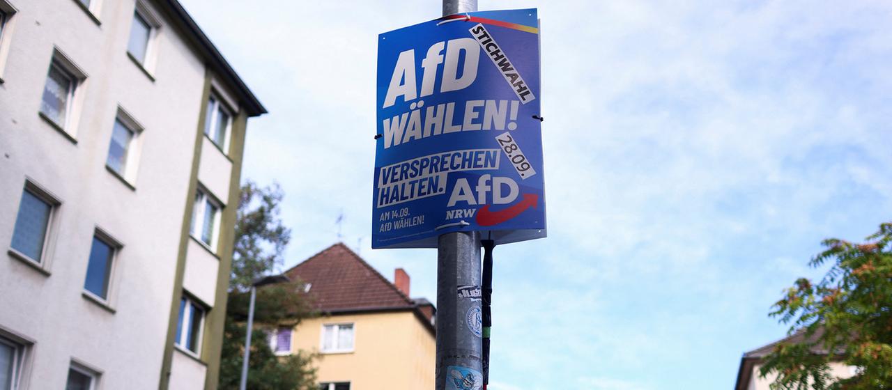 Ein AfD-Mitglied befestigt in Gelsenkirchen ein Wahlplakat der AfD.