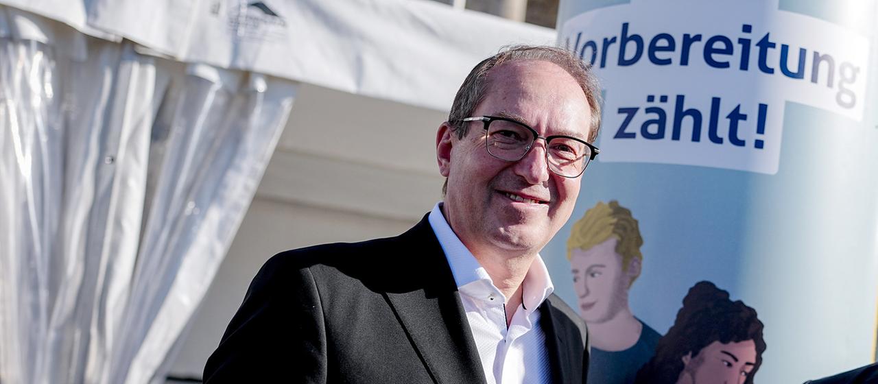 Alexander Dobrindt steht vor einem Aufsteller mit der Aufschrift "Vorbereitung zählt!". 