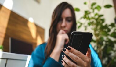 Eine junge Frau hält ein Android-Smartphone und wundert sich über den grünen Punkt