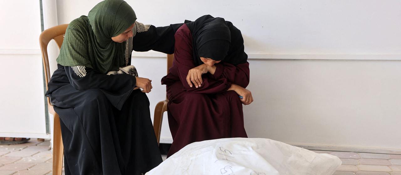 Angehörige sitzen neben einem Leichensack im Nasser-Krankenhauses in Chan Junis im südlichen Gazastreifen. | AFP Angehörige sitzen neben einem Leichensack im Nasser-Krankenhauses in Chan Junis im südlichen Gazastreifen.