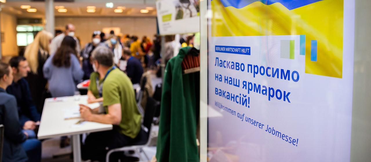 Menschen unterhalten sich bei einer Jobmesse für ukrainische Geflüchtete. | picture alliance/dpa Menschen unterhalten sich bei einer Jobmesse für ukrainische Geflüchtete.
