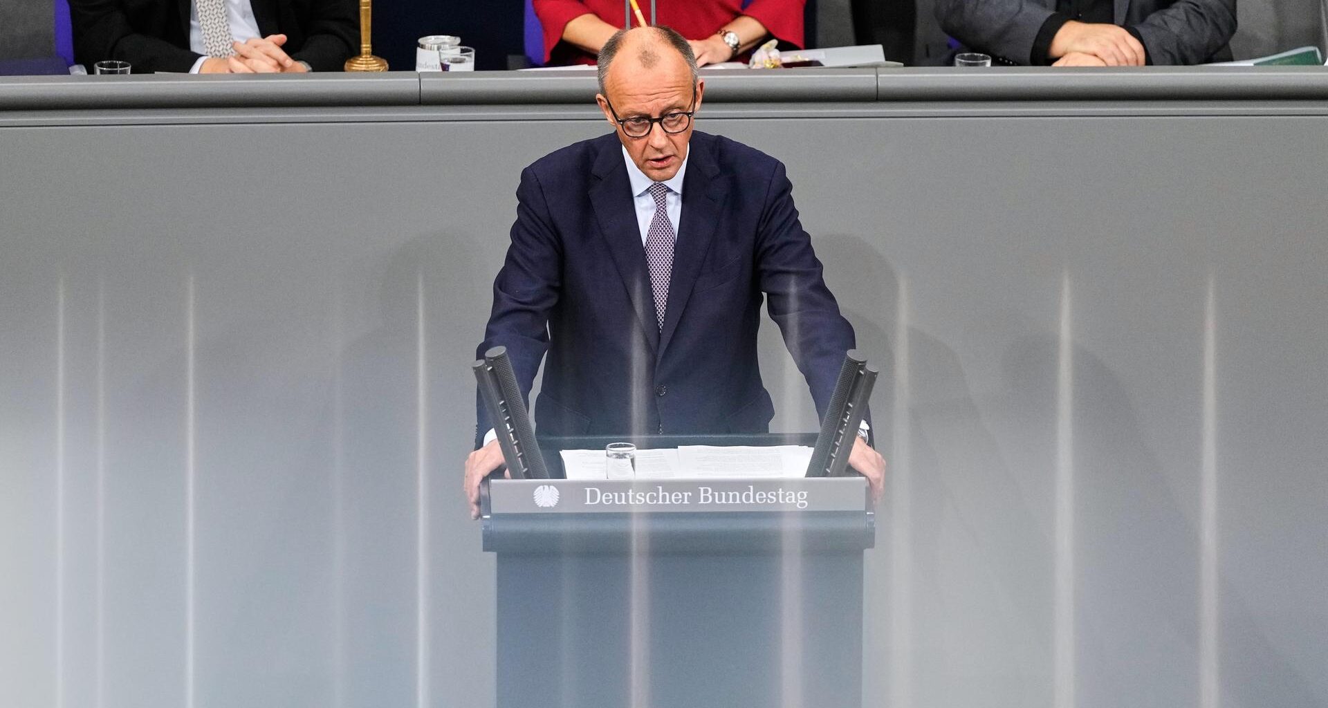 Bundeskanzler Merz steht im Bundestag hinter einem Rednerpult.