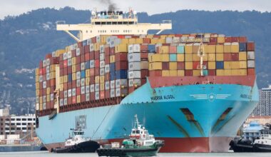 Ein Schlepper leitet ein Containerschiff im Hafen von Oakland, Kalifornien