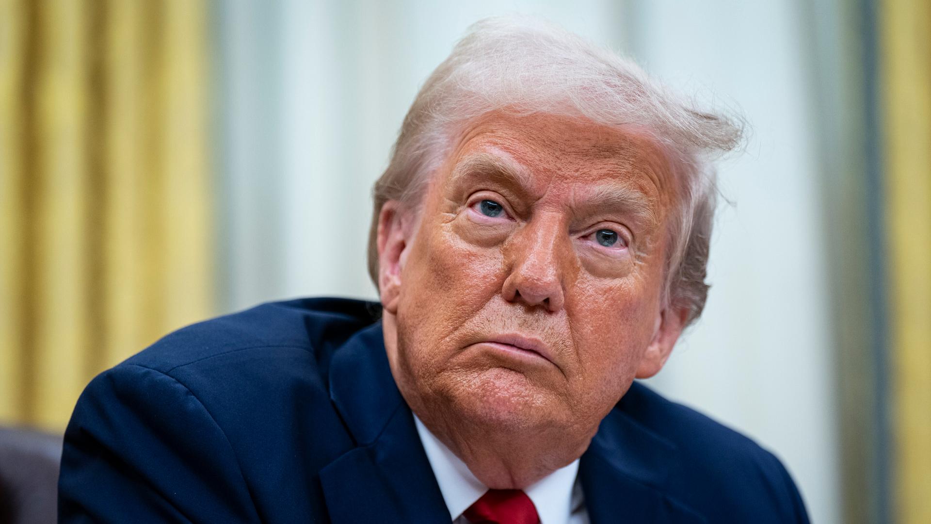 US-Präsident Trump im Oval Office des Weißen Hauses in Washington;er ist im Portrait zu sehen und schaut ernst.