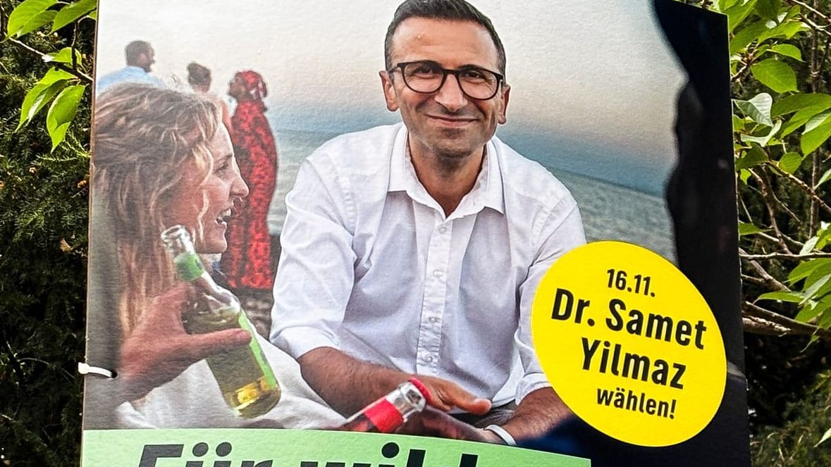 Ein Wahlplakat von Samet Yilmaz hängt an einem Laternenmast. Der Kieler Oberbürgermeister-Kandidat der Grünen soll ein Extremistenfest in Kiel unterstützt haben.