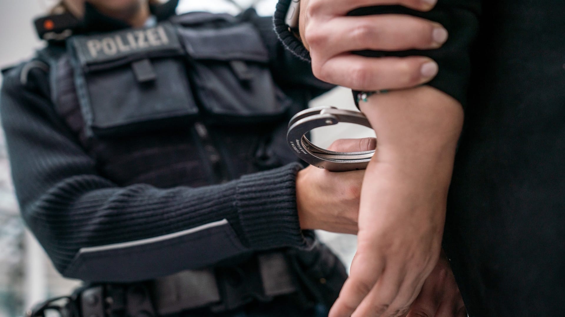 Eine Beamtin der Bundespolizei nimmt einen Mann fest (Symbolbild): Der 50-Jährige kam in Auslieferungshaft.