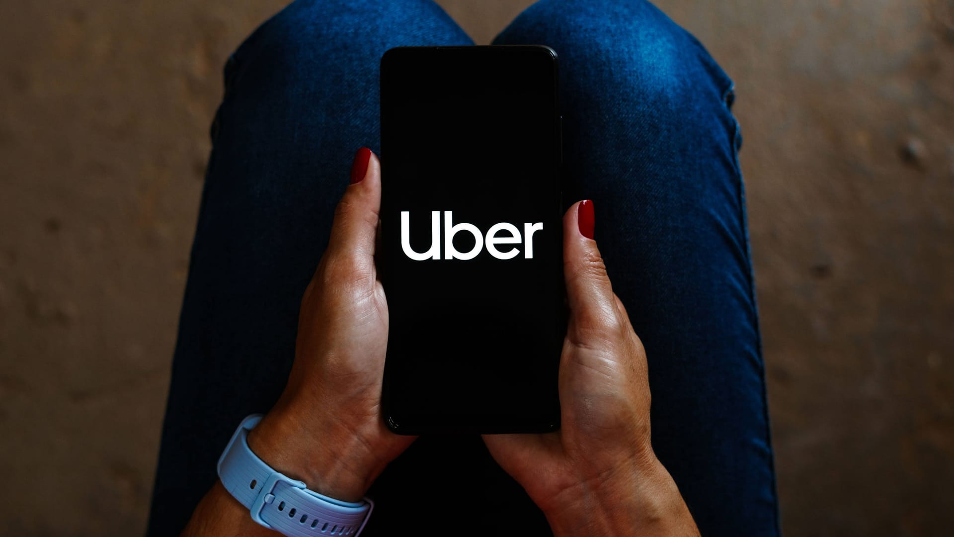 Eine Frau öffnet die Uber-App auf ihrem Smartphone (Symbolbild): In Braunschweig hat die Polizei einen mutmaßlichen Vergewaltiger festgenommen.