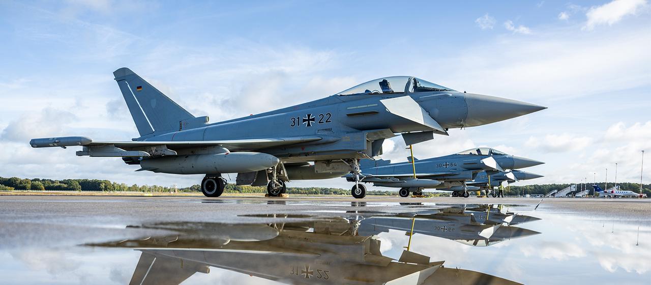Eurofighter spiegeln sich in einer Pfütze am Flughafen Münster-Osnabrück.