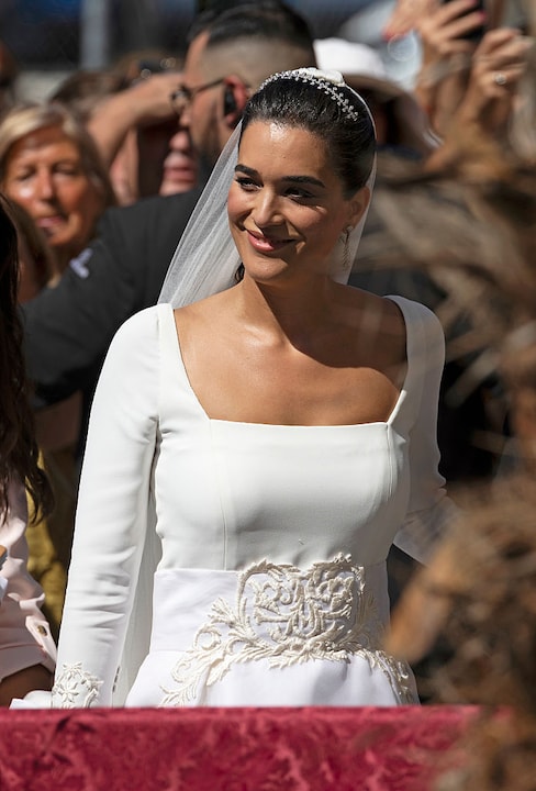 Braut Bárbara Mirjan trägt ein weißes Kleid mit Stickerei und eckigem Ausschnitt.
