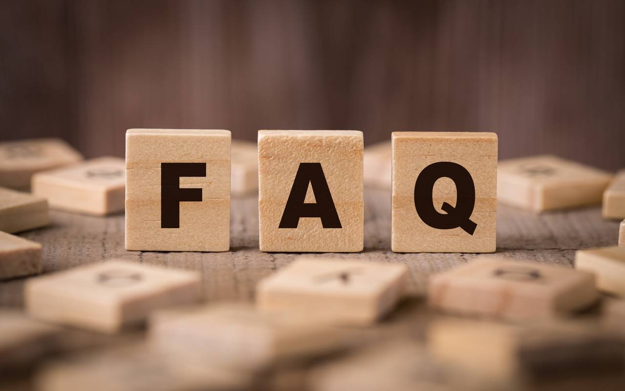 Ein FAQ-Schild in Form von hölzernen Bauklötzen.