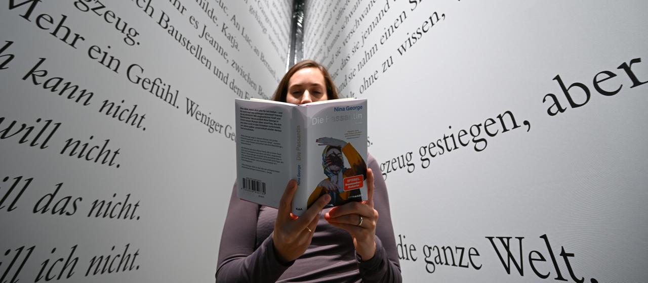 Eine Frau hält ein Buch. | dpa Eine Frau hält ein Buch.