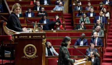 Man sieht im Vordergrund eine Frau im erhöhten Parlalementspräsidium und eine weitere Frau am Rednerpult jeweils von der Seite. Dahinter unscharf Abgeordnete auf den roten Bänken.