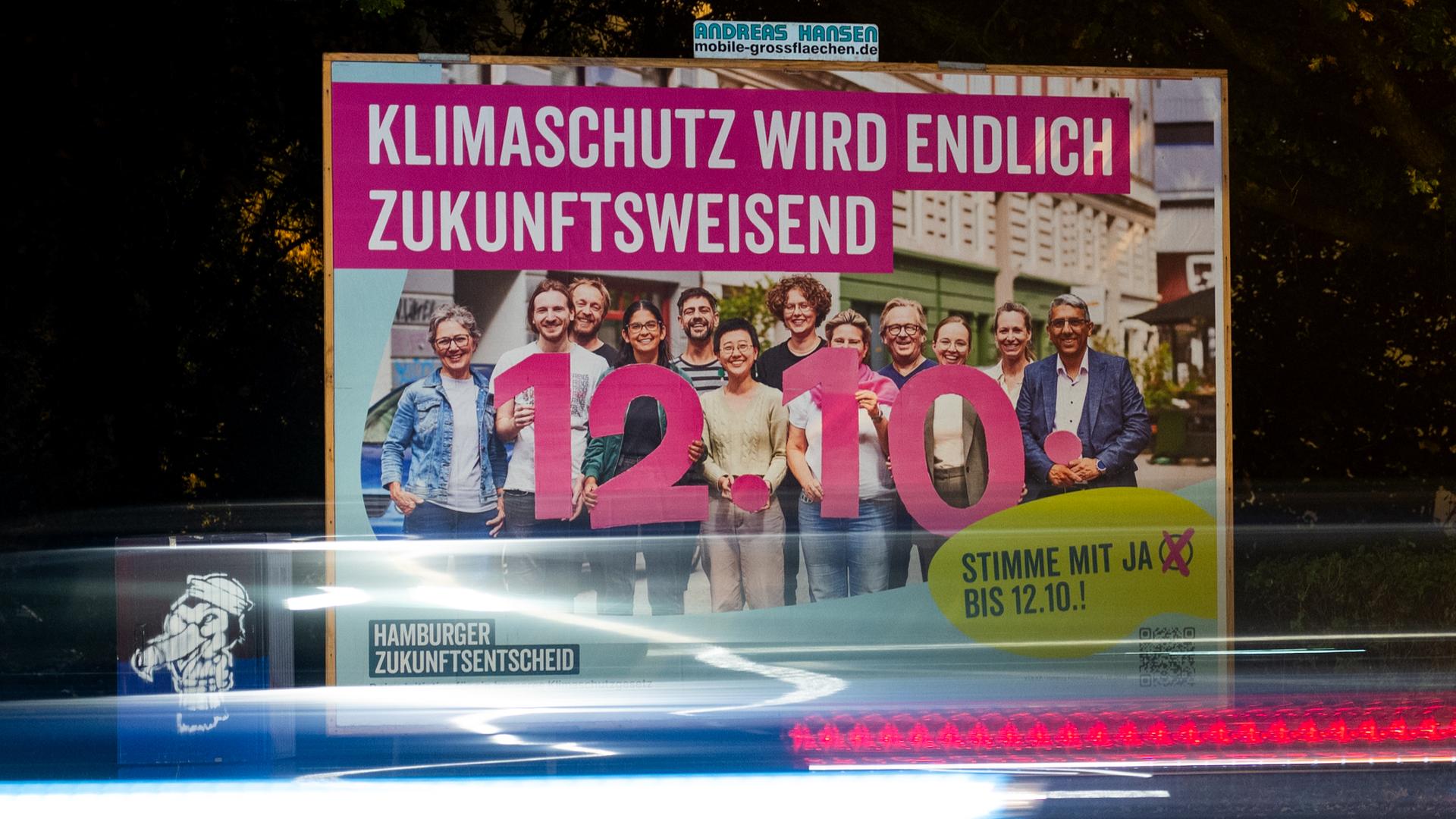 Ein Plakat für den Hamburger Zukunftsentscheid mit der Aufschrift "Klimaschutz wird endlich zukunftsweisend" steht an einer Straße.