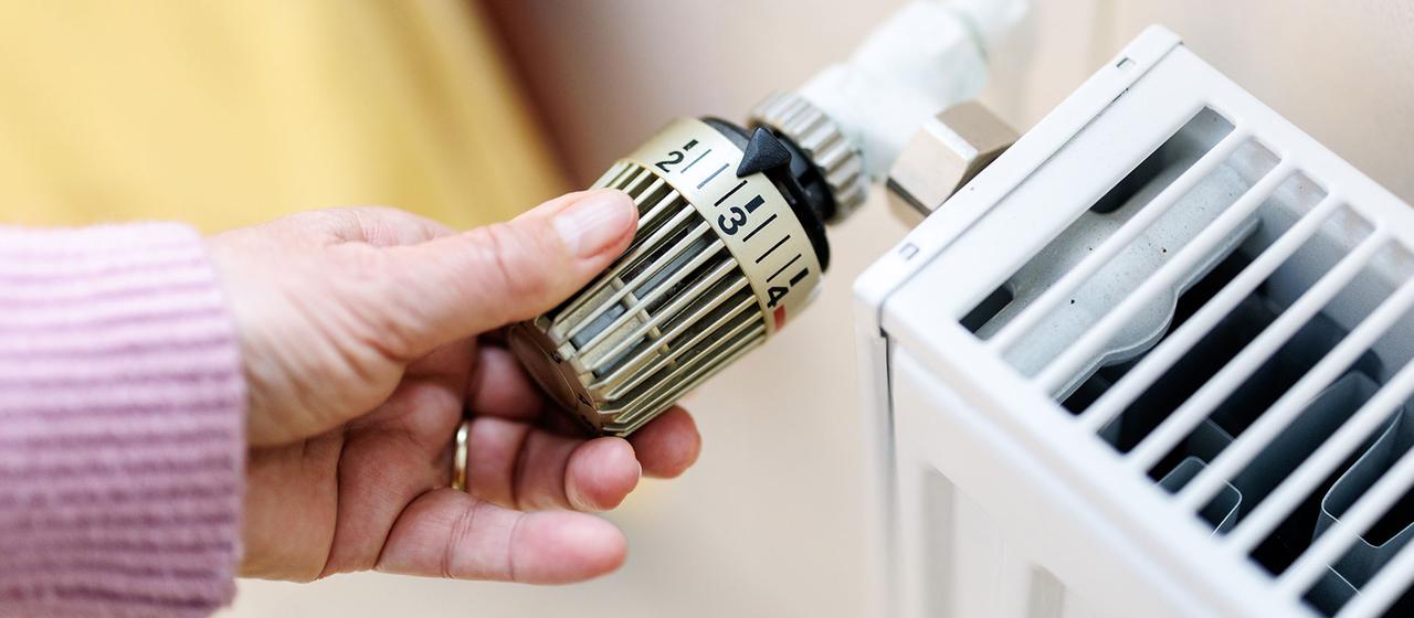 Eine Frau stellt an einem Thermostaten die Temperatur von einem Heizkörper ein. | dpa Eine Frau stellt an einem Thermostaten die Temperatur von einem Heizkörper ein.