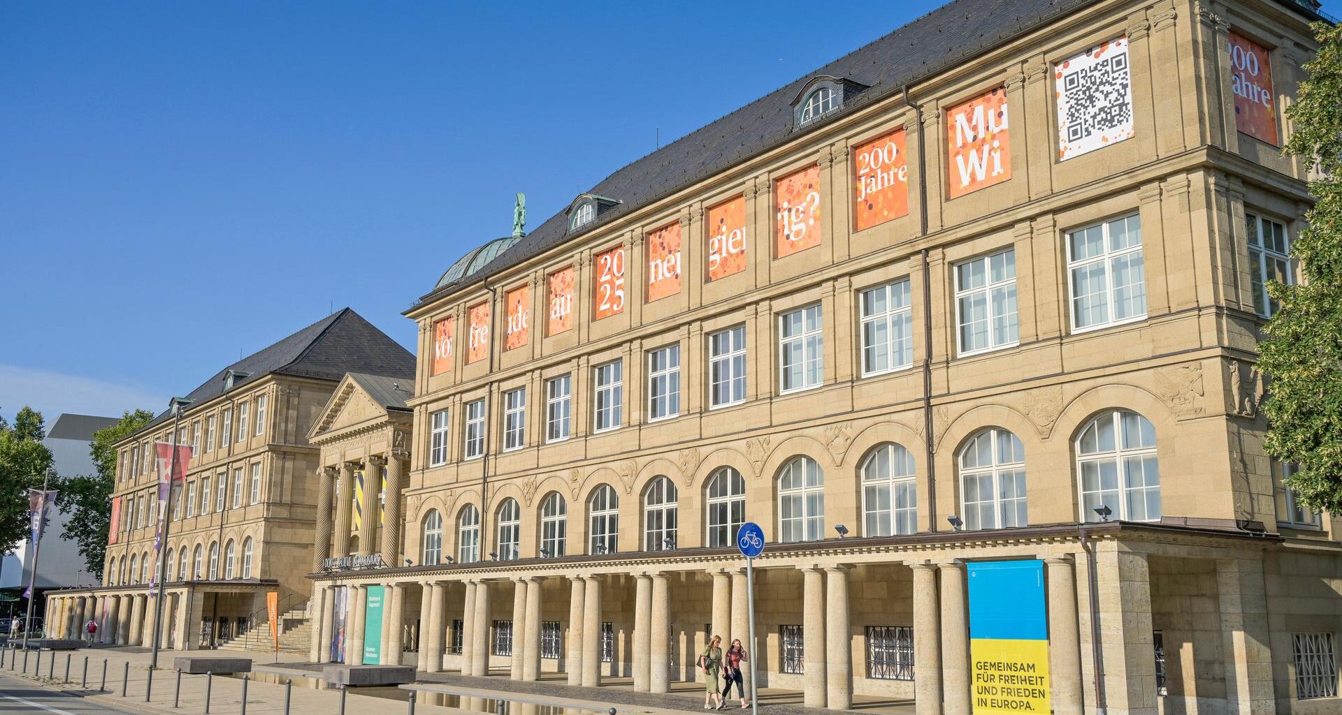 Die Frontfassade des Hessisches Landesmuseum für Kunst und Natur in Wiesbaden mit klassizistischem Einbgangsportal und zwei Seitenflügeln.