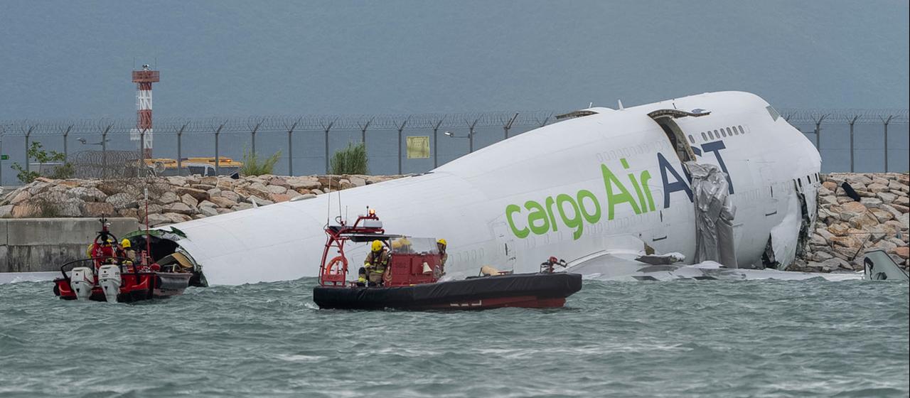 Rettungskräfte in Booten vor verunglücktem Frachtflugzeug
