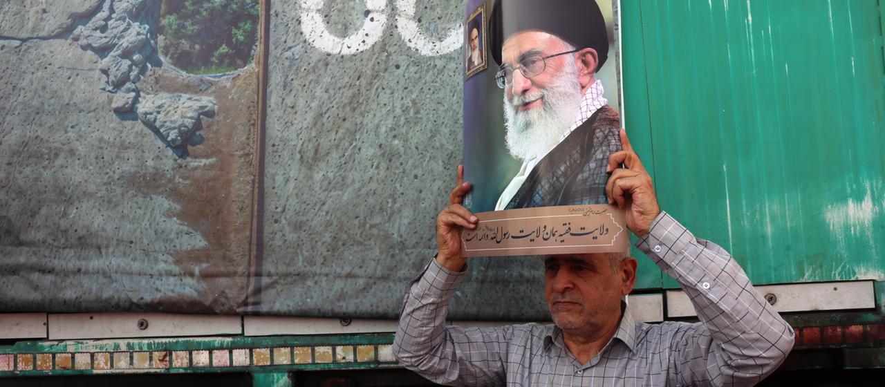 Auf einer Kundgebung in Teheran (Iran) zeigt ein Mann ein Bild von Ajatollah Chamenei.