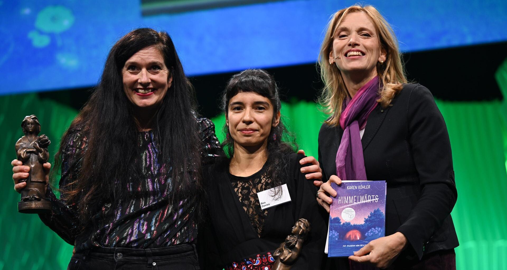 Die Autorin Karen Köhler (l) und die Illustratorin Bea Davies werden bei der Verleihung des Deutschen Jugendliteraturpreis 2025 auf der Frankfurter Buchmesse von Karin Prien mit der Momo-Trophäe ausgezeichnet.