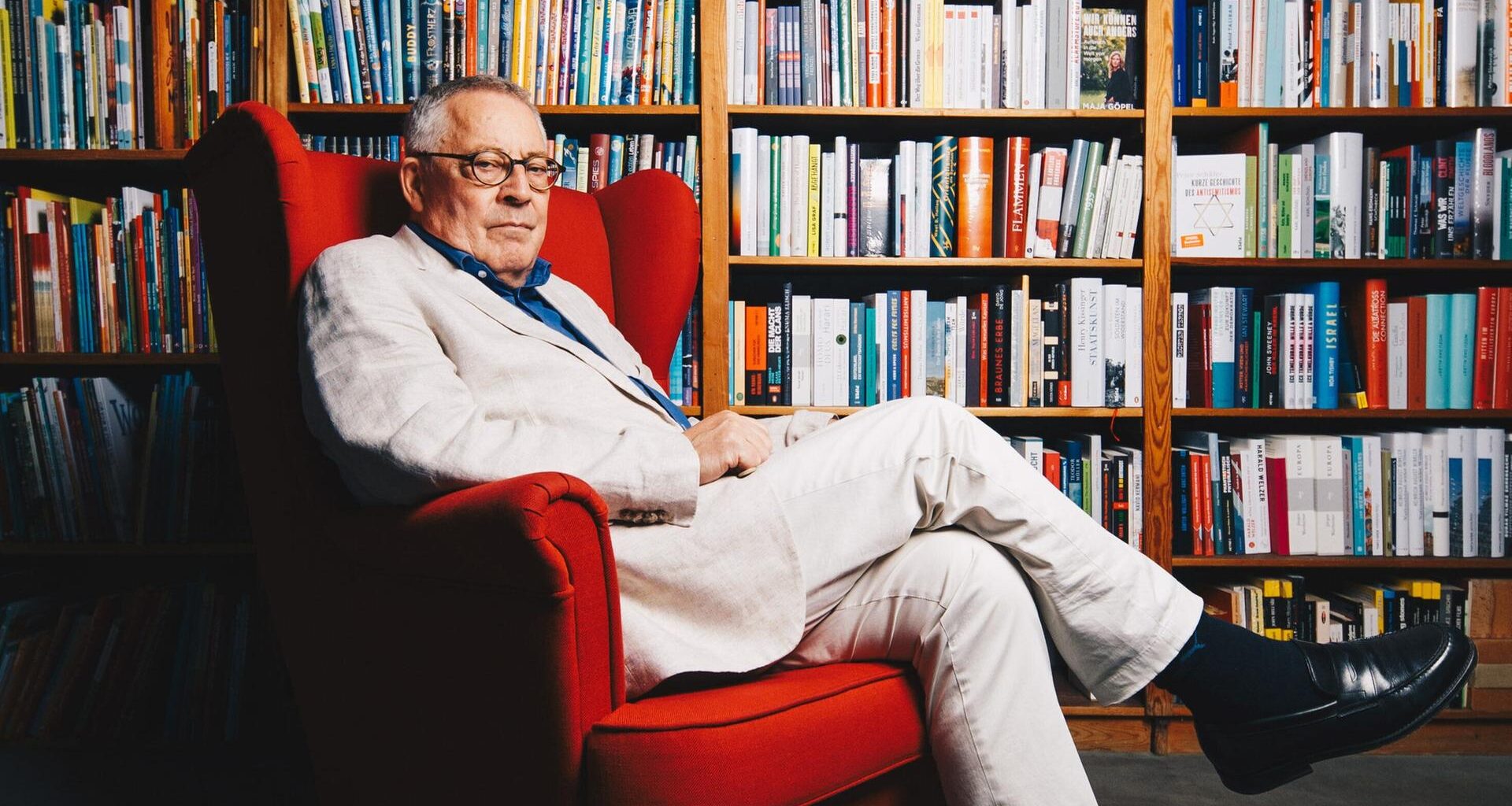 30.09.2022 - Berlin - Der Autor Karl Schlögel posiert in einem roten Sessel vor Bücherregalen in einer Buchhandlung am Bayrischen Platz in Berlin.
