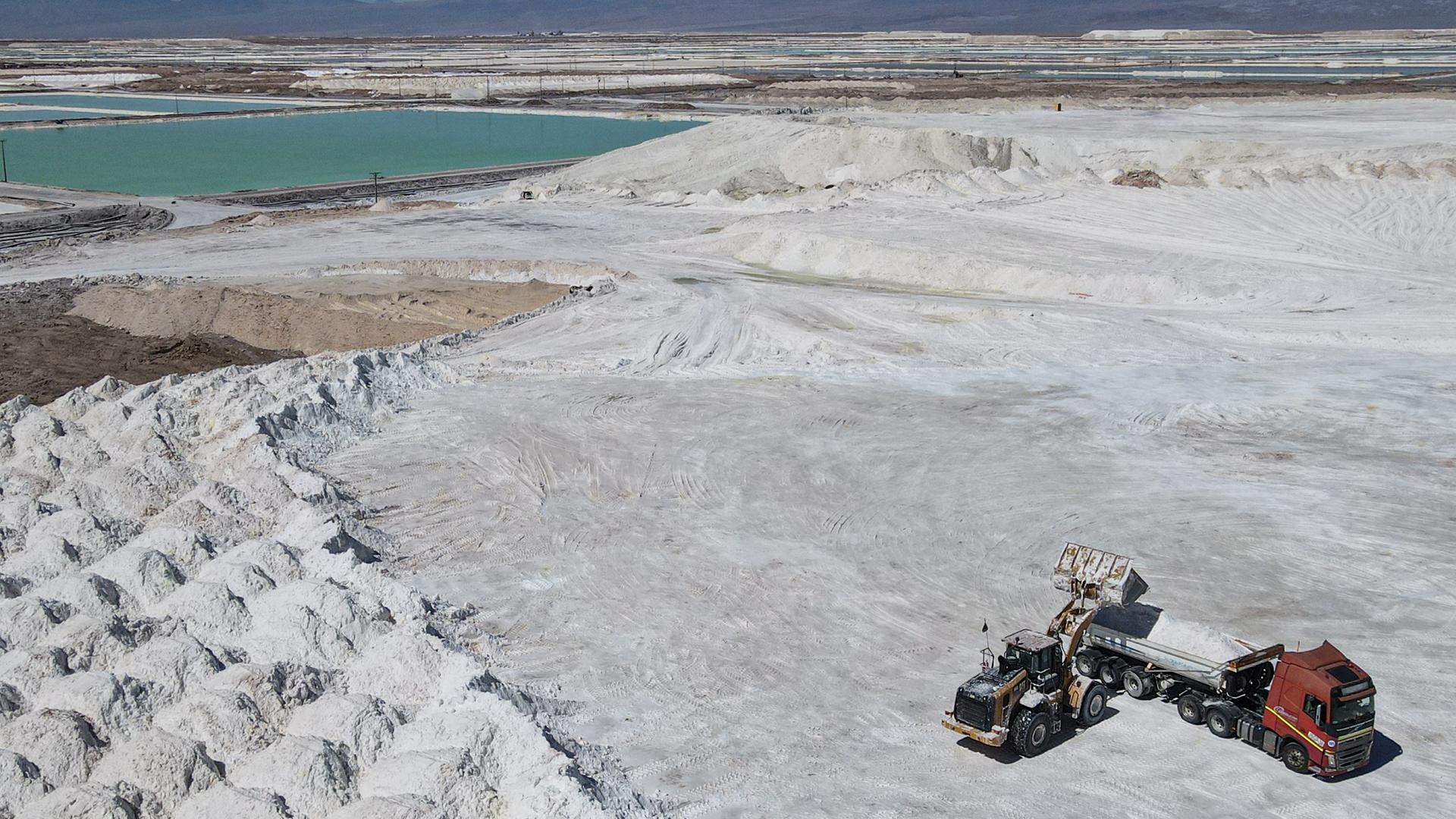 Arbeiter einer Lithiummine transportieren in der Atacama-Wüste im Salar de Atacama ein Nebenprodukt.  Arbeiter einer Lithiummine transportieren in der Atacama-Wüste im Salar de Atacama ein Nebenprodukt.