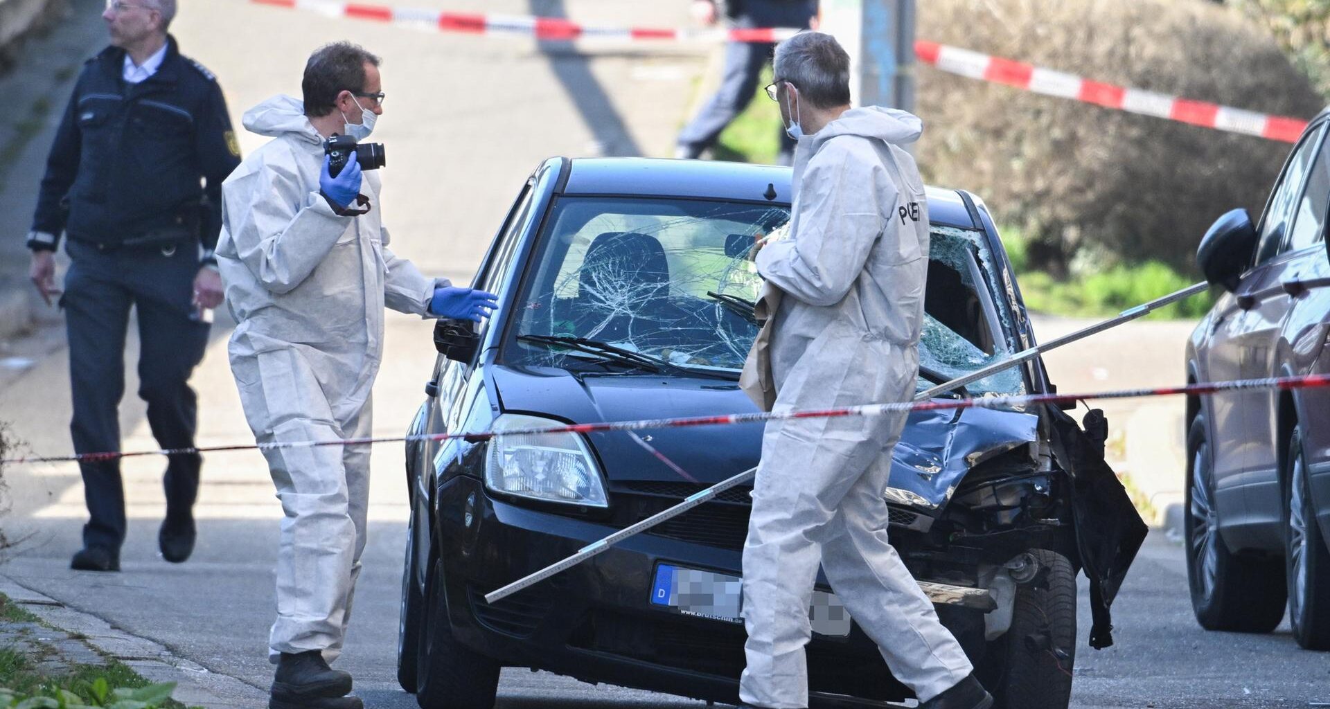 Mannheim: Beamte der Spurensicherung untersuchen ein beschädigtes Fahrzeug an einer Zufahrt zur Rheinbrücke,