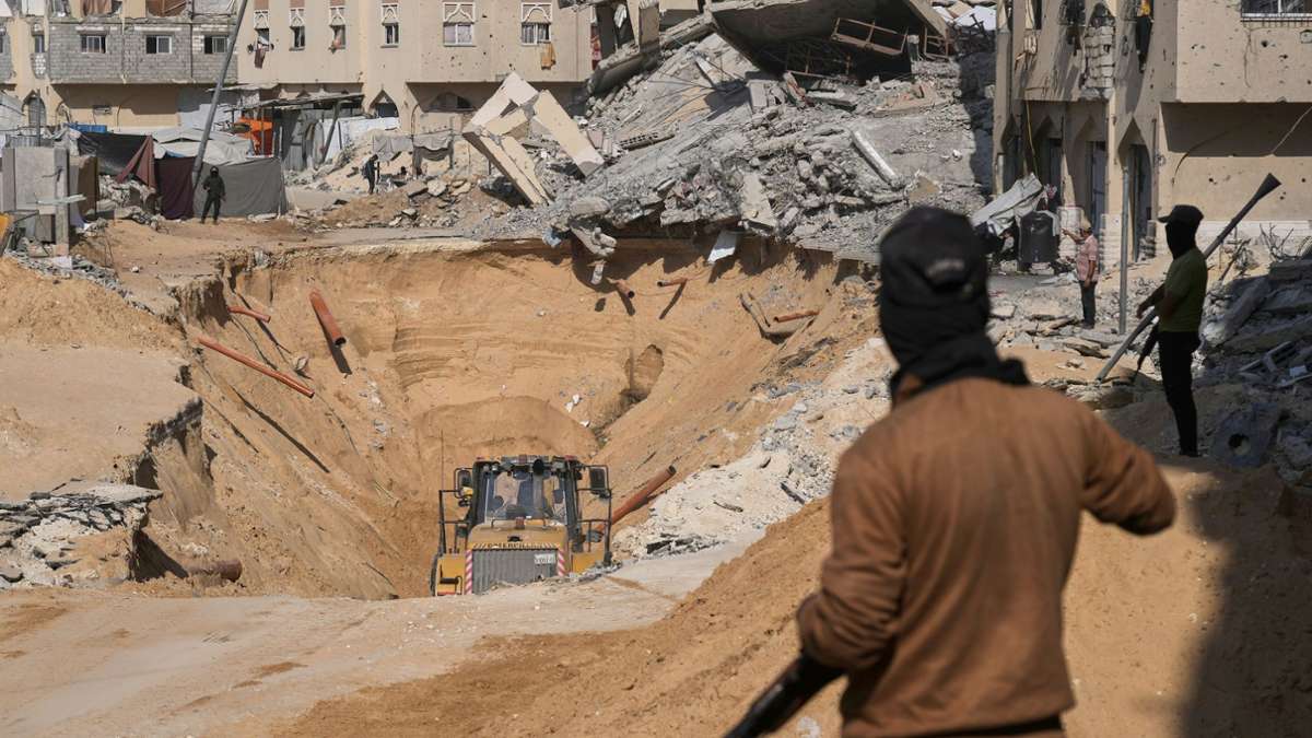 Mitglieder der militanten Hamas-Gruppe graben nach den Leichen israelischer Geiseln inmitten zerstörter Gebäude im südlichen Gazastreifen.