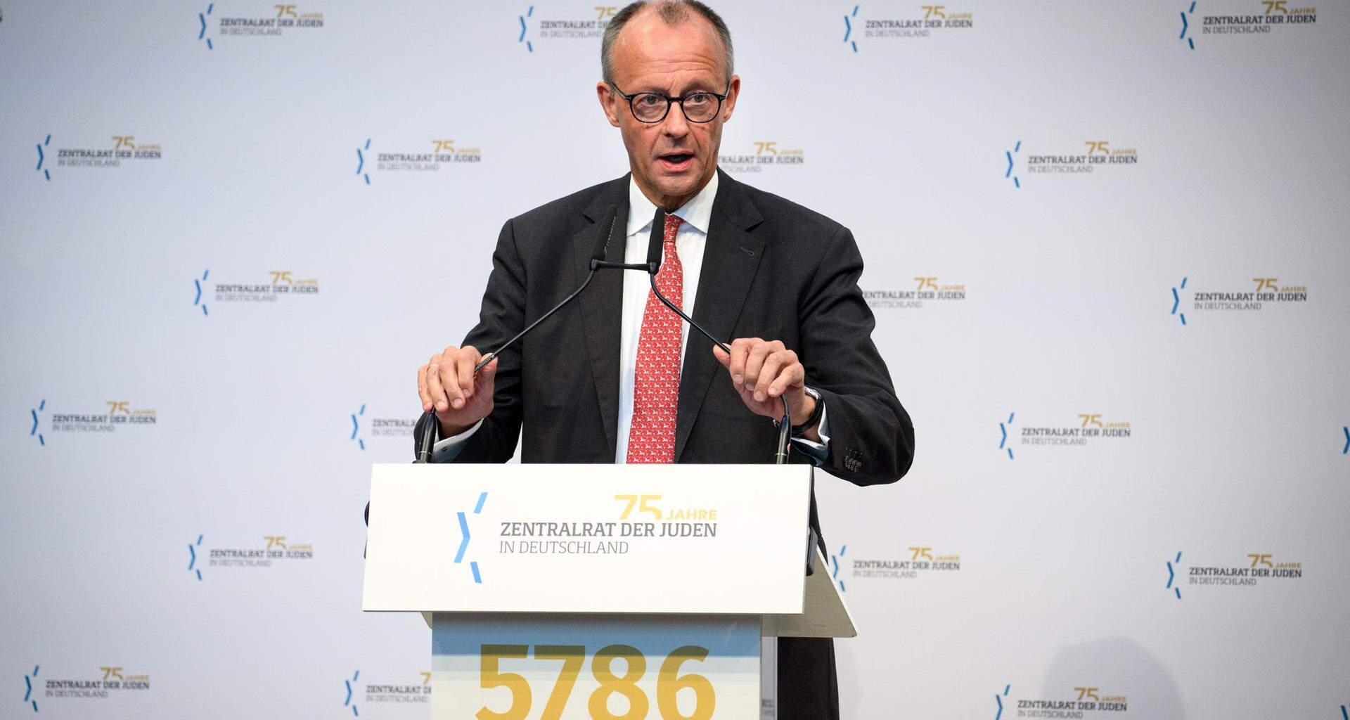 Bundeskanzler Friedrich Merz spricht an einem Rednerpult.