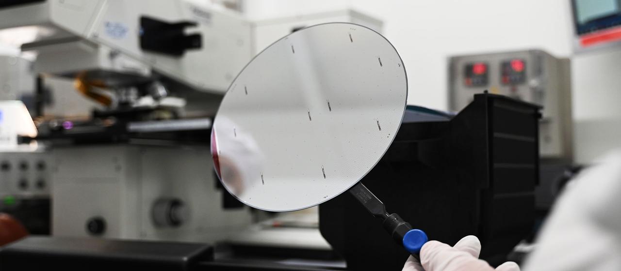 Ein Mitarbeiter der Nexperia Germany GmbH mit einen sogenannten Wafer.