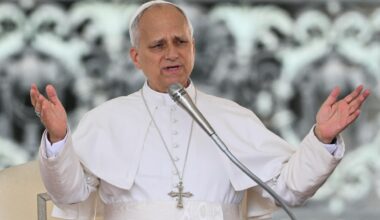Papst Leo hat seine Arme ausgebreitet und spricht in ein Mikrofon.