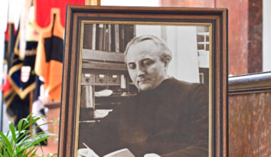 Ein Foto von Max Josef Metzger steht in einer Kirche vor einer Reihe von Bannern