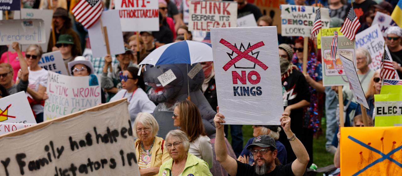Teilnehmer einer "No kings"-Demonstration in Landing im US-Bundesstaat Michigan halten Schilder hoch.