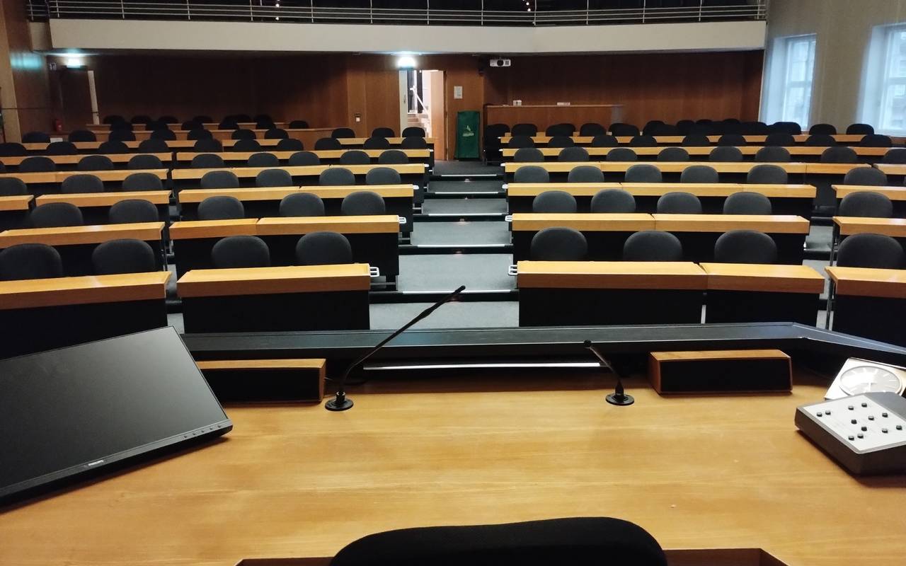 Blick in den leeren Ratssaal im Düsseldorfer Rathaus. Auf dem Tisch des OB stehen Laptop, Mikrofon und eine alte Uhr.