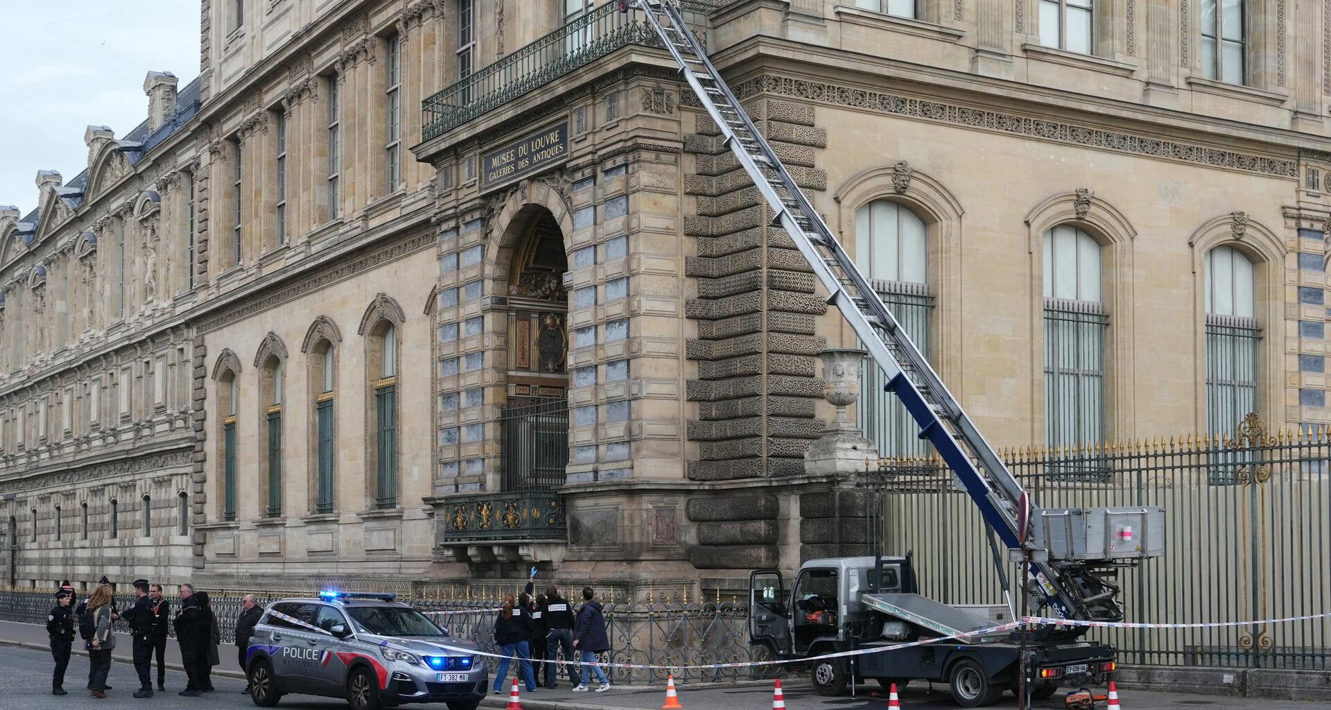 Französische Polizisten neben einem Möbelaufzug, der für den Raubüberfall auf das Museum Louvre in Paris verwendet wurde.