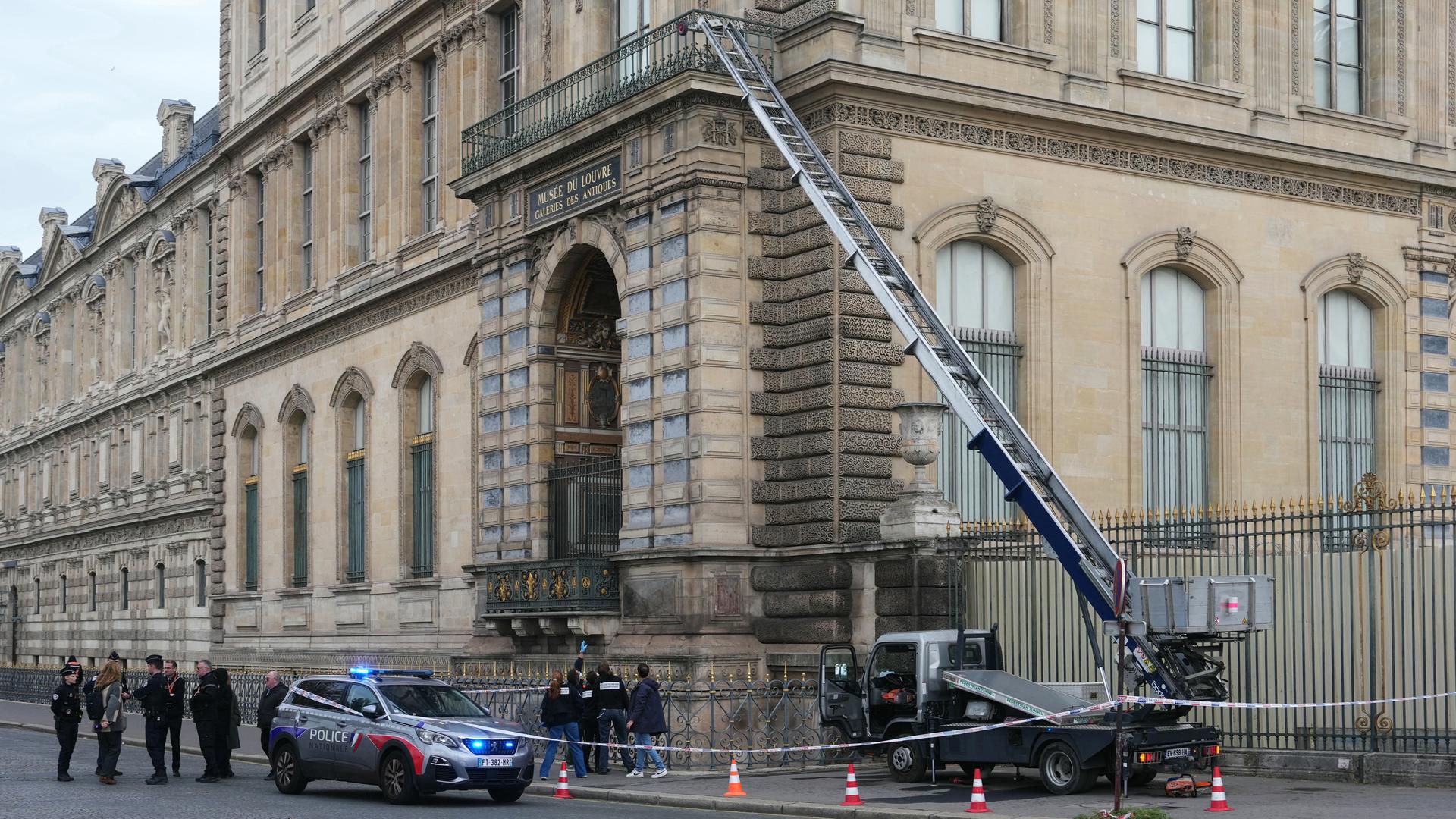 Französische Polizisten neben einem Möbelaufzug, der für den Raubüberfall auf das Museum Louvre in Paris verwendet wurde.