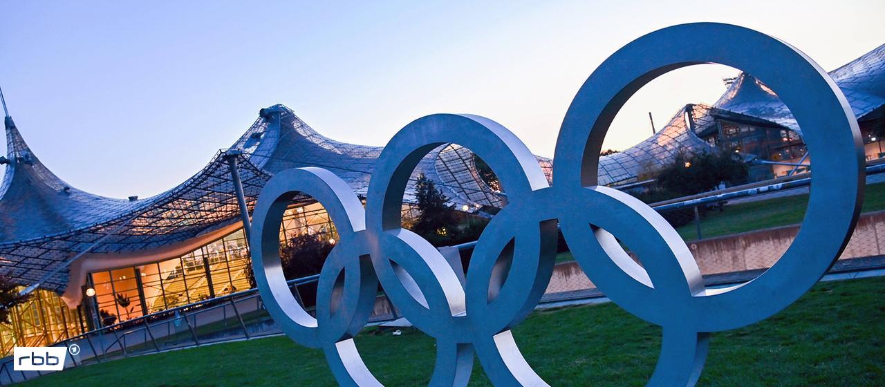 Olympische Ringe im Olympiapark in München | IMAGO / Sven Simon Olympische Ringe im Olympiapark in München (Quelle: IMAGO / Sven Simon)