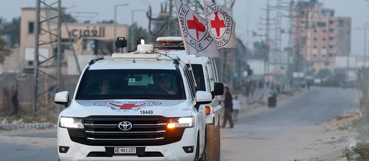Ein Konvoi des Roten Kreuzes fährt an Trümmern vorbei