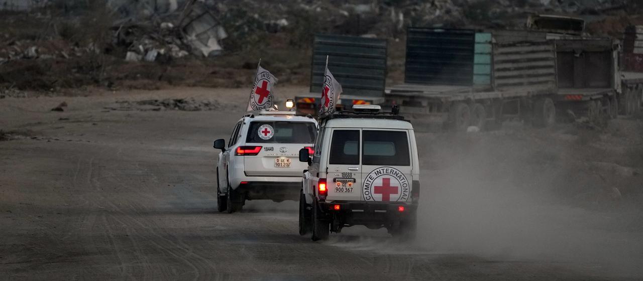 Fahrzeuge des Roten Kreuzes, transportieren die Leichen von zwei vermutlichen Geiseln raus dem Gazastreifen.