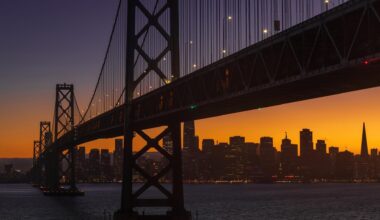 Die Bay Bridge am frühen Abend in San Francisco. Im Hintergrund geht die Sonne unter.