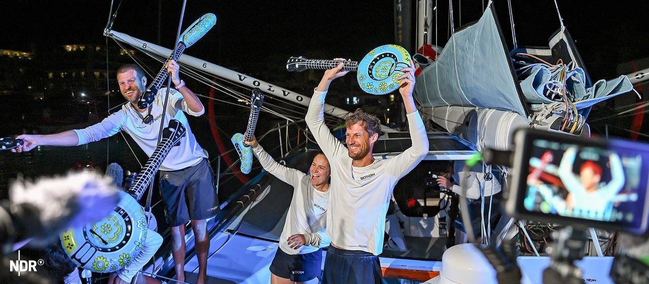 Die Biotherm-Crew jubelt mit aufblasbaren Musikinstrumenten.