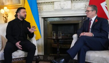 Der ukrainische Präsident Wolodymyr Selensykj (l.) und der britische Premierminister Keir Starmer (r.) sitzen nebeneinander, hinter ihnen die Nationalflaggen. Selenskyj spricht und gestikuliert.