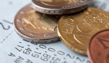 Auf einem Kassenzettel liegen verschiedene Euro-Münzen.