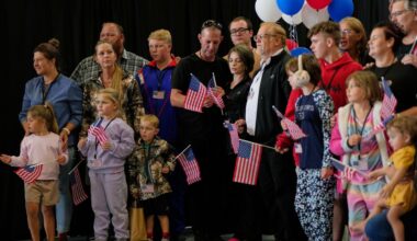 Die erste Gruppe weißer Südafrikaner, denen die US-Regierung Flüchtlingsstatus erteilt hat, trifft mit US-Fähnchen am Dulles International Airport ein.