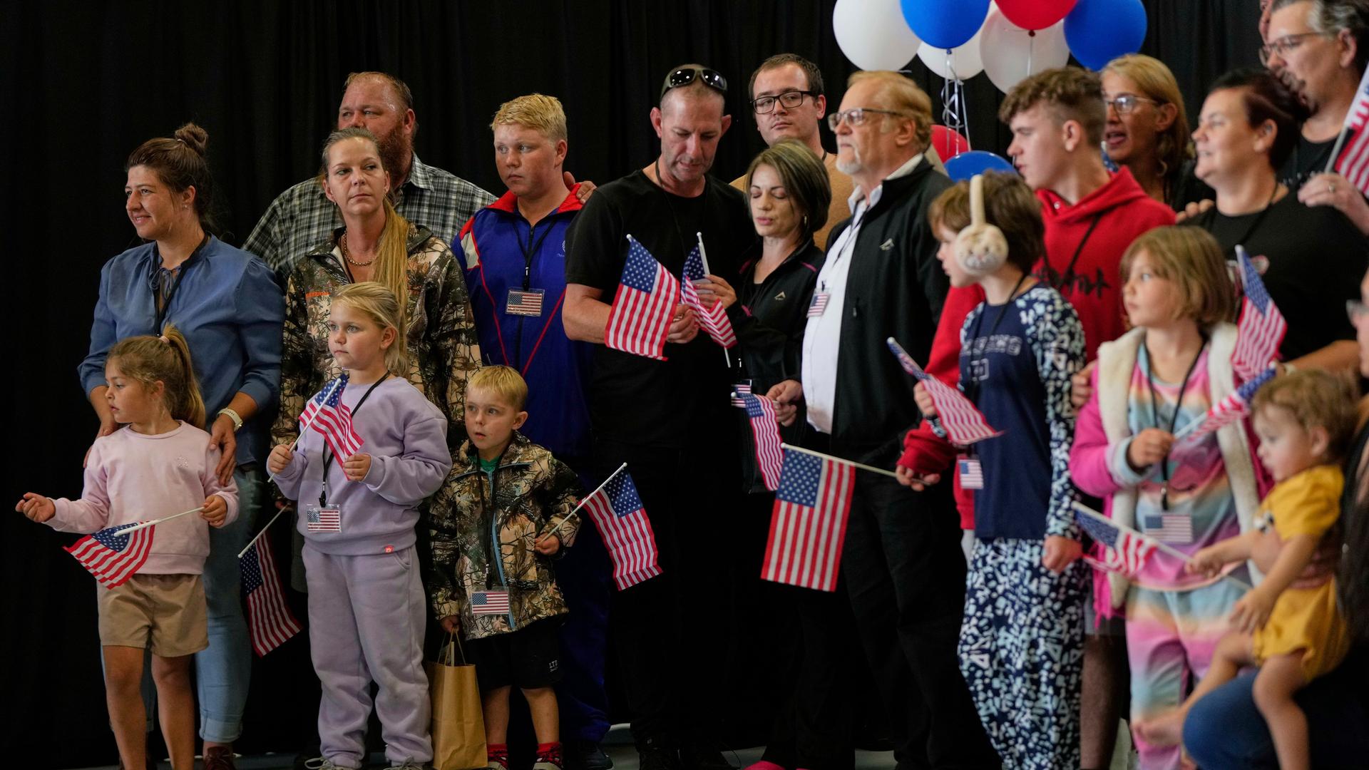 Die erste Gruppe weißer Südafrikaner, denen die US-Regierung Flüchtlingsstatus erteilt hat, trifft mit US-Fähnchen am Dulles International Airport ein. Die erste Gruppe weißer Südafrikaner, denen die US-Regierung Flüchtlingsstatus erteilt hat, trifft mit US-Fähnchen am Dulles International Airport ein.