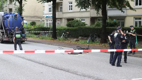 Ein abgesperrter Unfallort bei dem ein Fahrrad auf der Straße liegt.