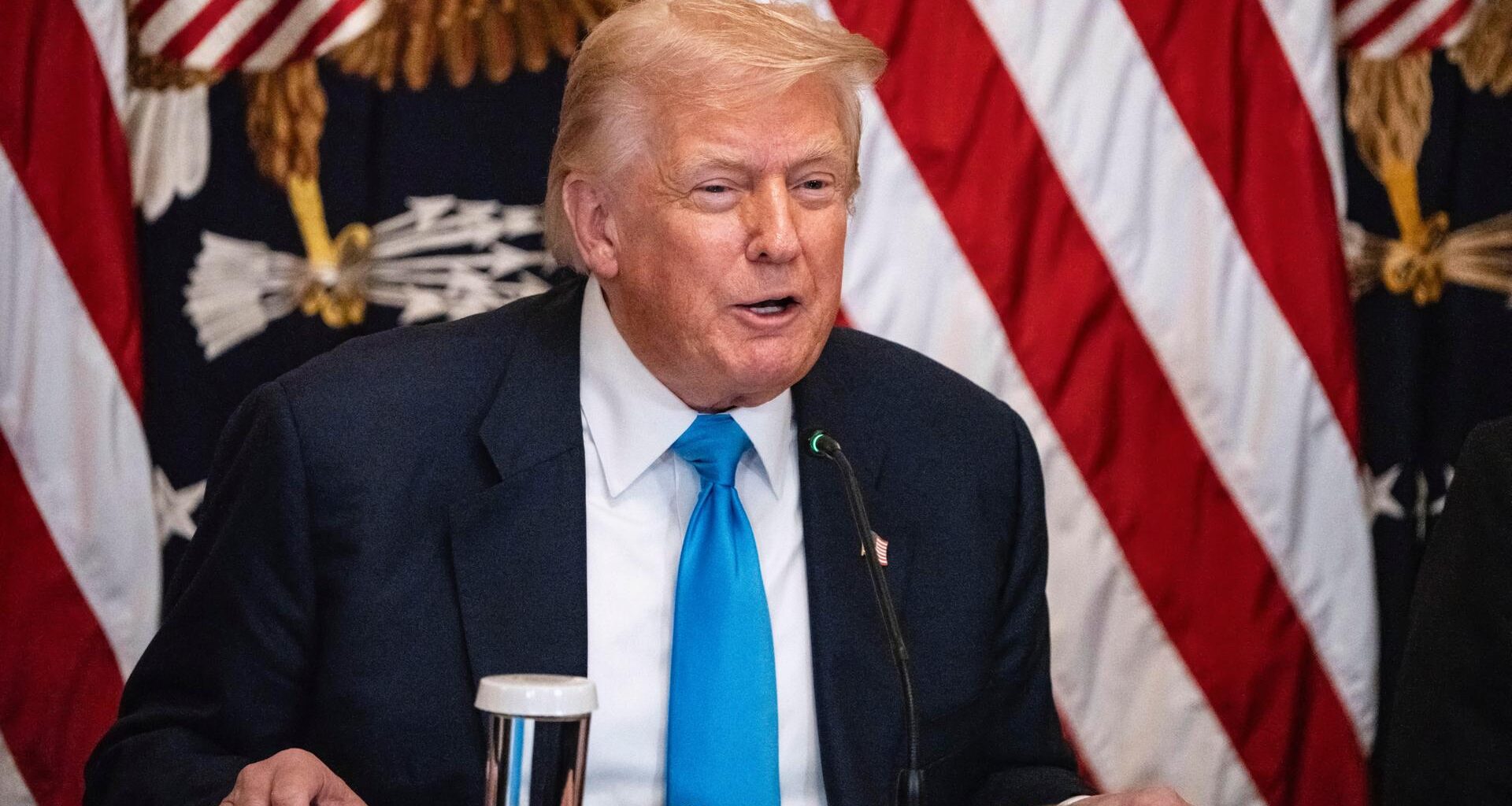 US-Präsident Donald Trump spricht im Weißen Haus zum Thema "Making Health Technology Great Again". Er sitzt an einem Schreibtisch, hinter ihm die Flagge der Vereinigten Staaten von Amerika.