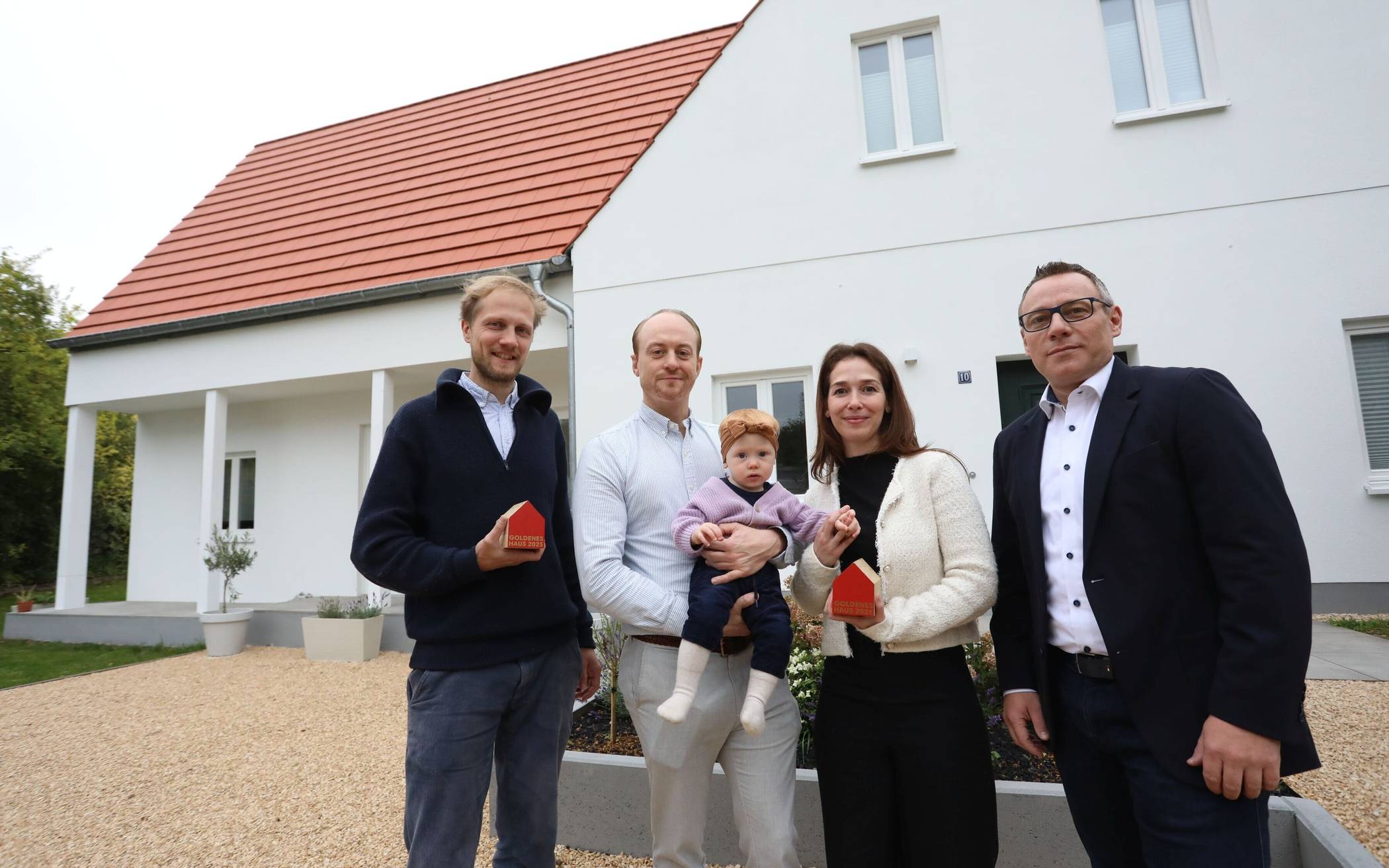  Architekturpreis für modernisierten Altbau in Sankt Augustin (v.l.): Architekt Lucas Schrader, Leonard Stühl mit Tochter Amilia, Miriam Cockx-Stühl und LBS-Gebietsleiter Thomas Busch vor dem ausgezeichneten Gebäude an der Steinkreuzstrasse in Niederpleis. 