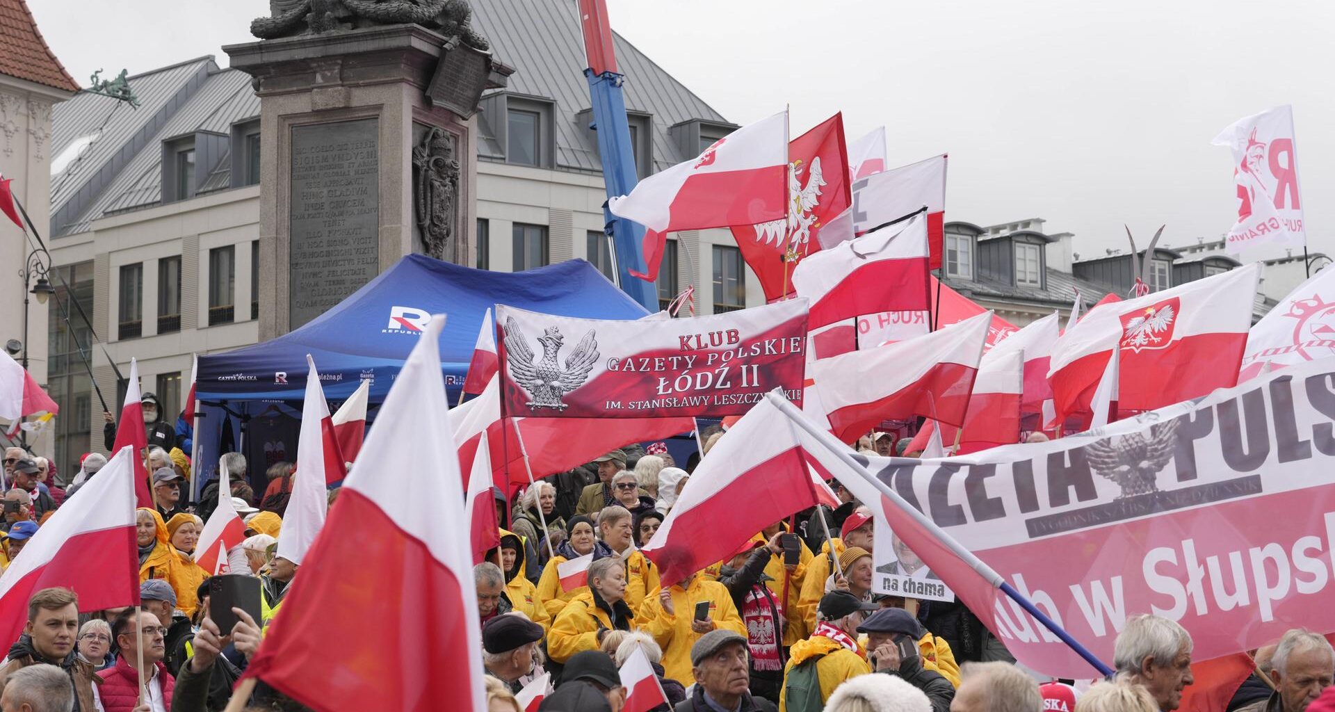 Demonstranten auf dem Schlossplatz in Warschau. Sie schwenken Fahnen.